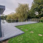 garden Trex decking design with glass balustrade in weybridge
